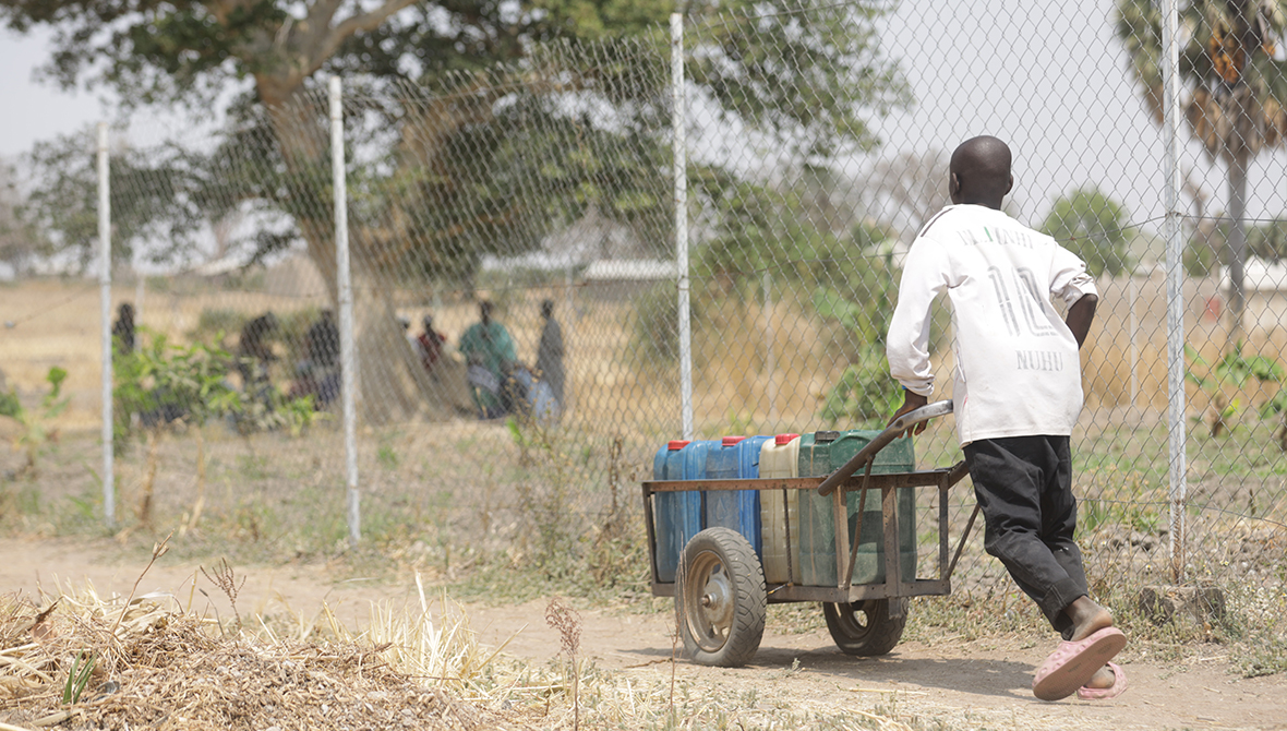 A young boy pushing a barrel of water from the Rural Resource Center in Tchamba, Cameroon.