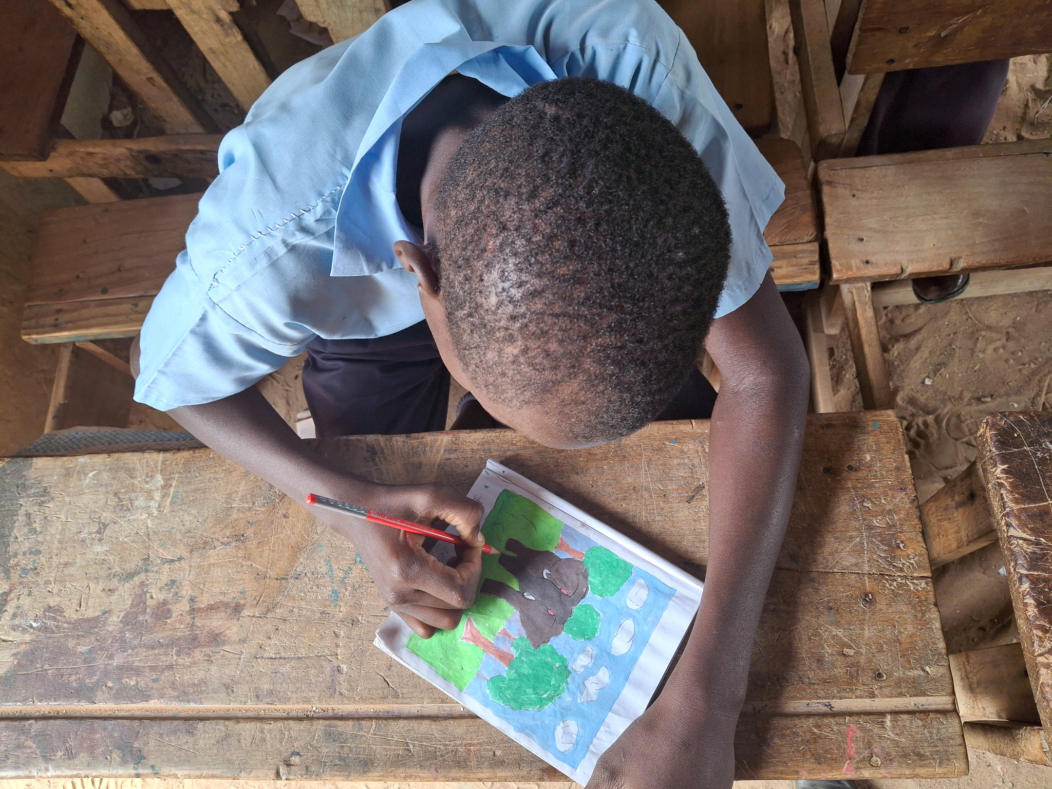 Bakari drawing one of his pictures.