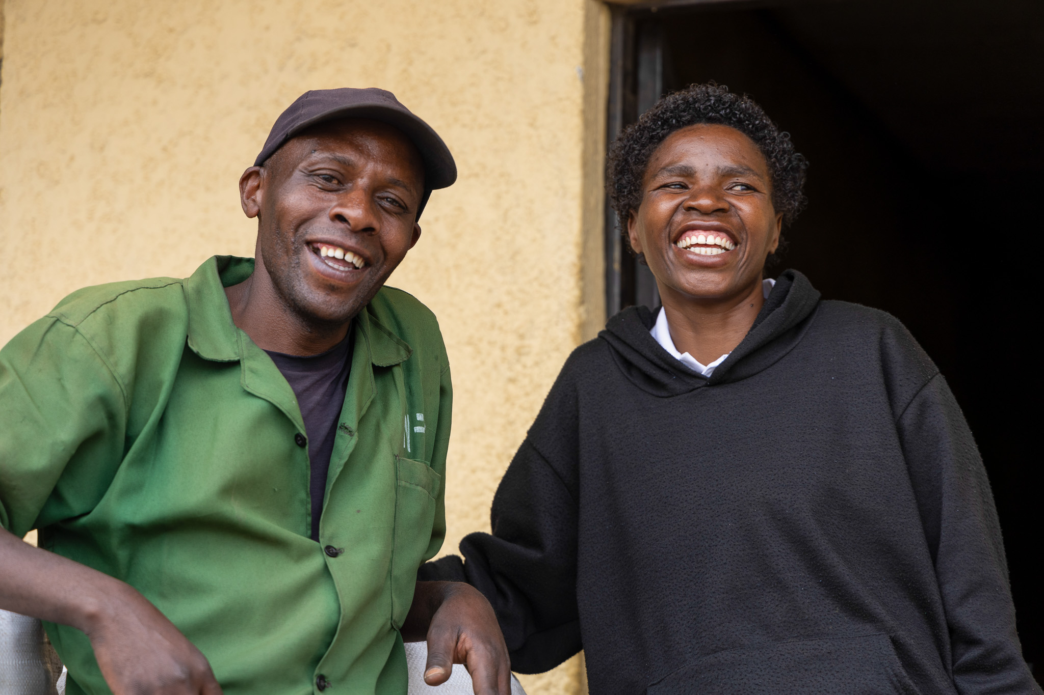 Mukarwego Agnes with a community member outside her home in the Virungas landscape.