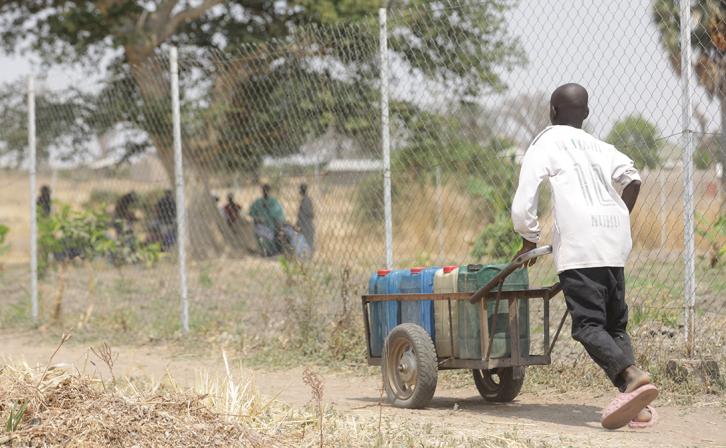 A young boy pushing a barrel of water from the Rural Resource Center in Tchamba, Cameroon.