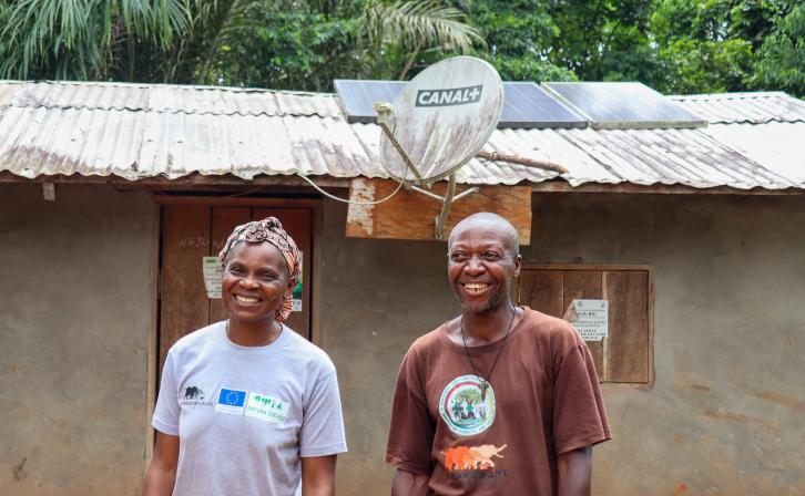 Clautilde and Sere Etienne stand infront of their Solar powered home, Dja, Cameroon.