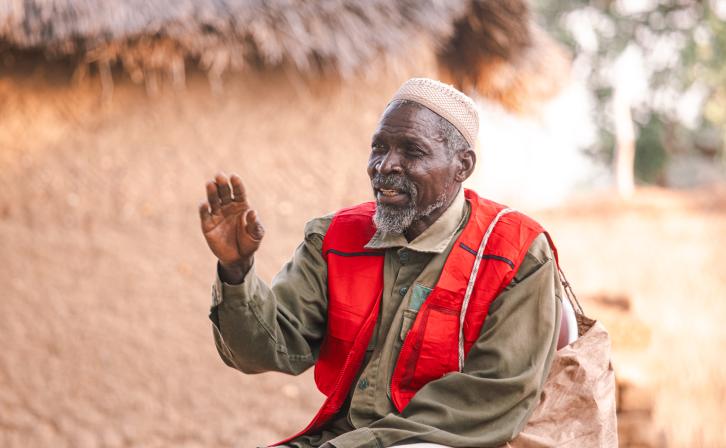 Papa Gambo sitting outside his house