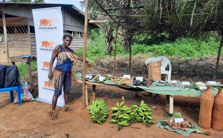 A Bagyeli Indigenous woman displays medicinal plants and harvested crops.