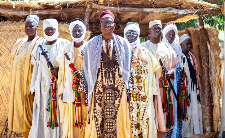 Hayatou Adji, traditional ruler of Voko, stands in front of his palace with members of his council.