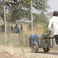 A young boy pushing a barrel of water from the Rural Resource Center in Tchamba, Cameroon.