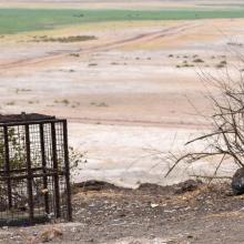 Small bits of plastic are littered around a bin on a scenic overlook.