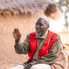 Papa Gambo sitting outside his house